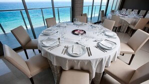 Een ronde eettafel gedekt voor een maaltijd, met uitzicht op zee.