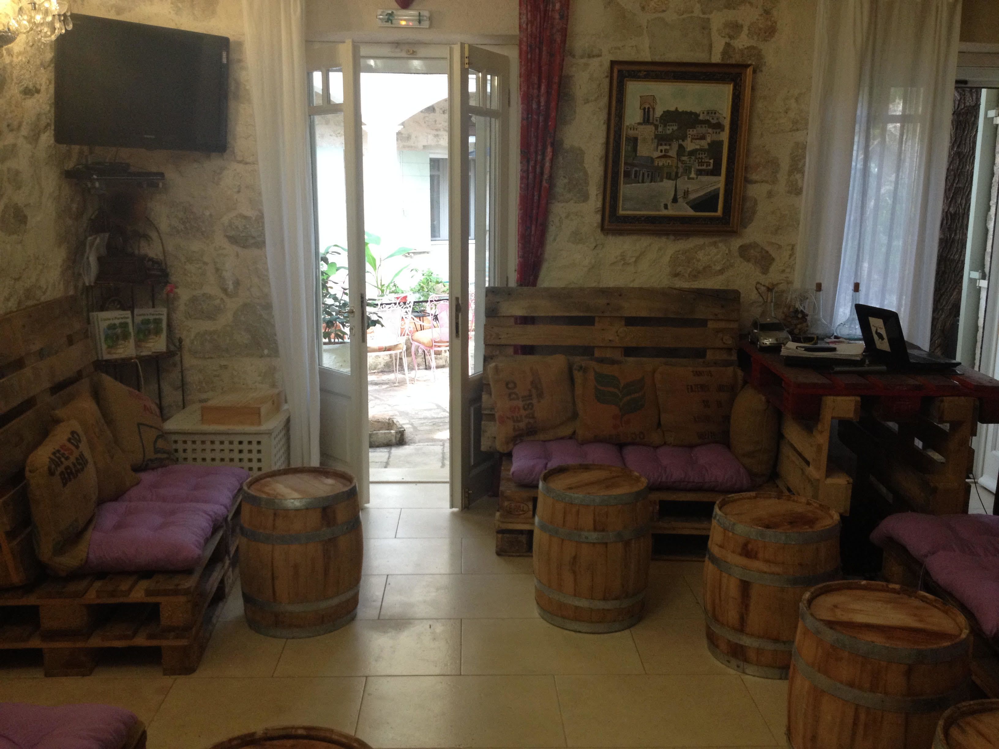 A rustic room with a stone wall, wooden furniture, and barrels.