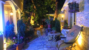 Une terrasse extérieure agrémentée de plantes en pot, d’une table et de chaises.