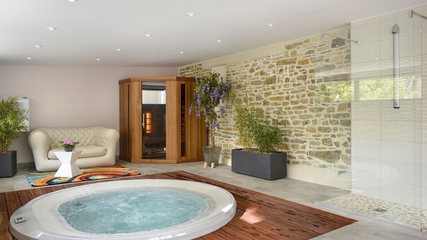 A modern bathroom with a stone wall, a wooden bathtub, and a glass shower enclosure. - Au Site Normand (Clecy)
