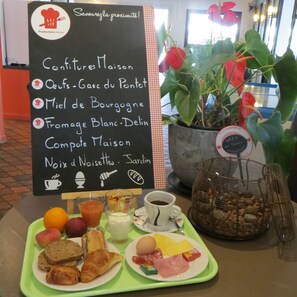 Un bufé de desayuno con una variedad de alimentos y un cartel que enumera el menú.