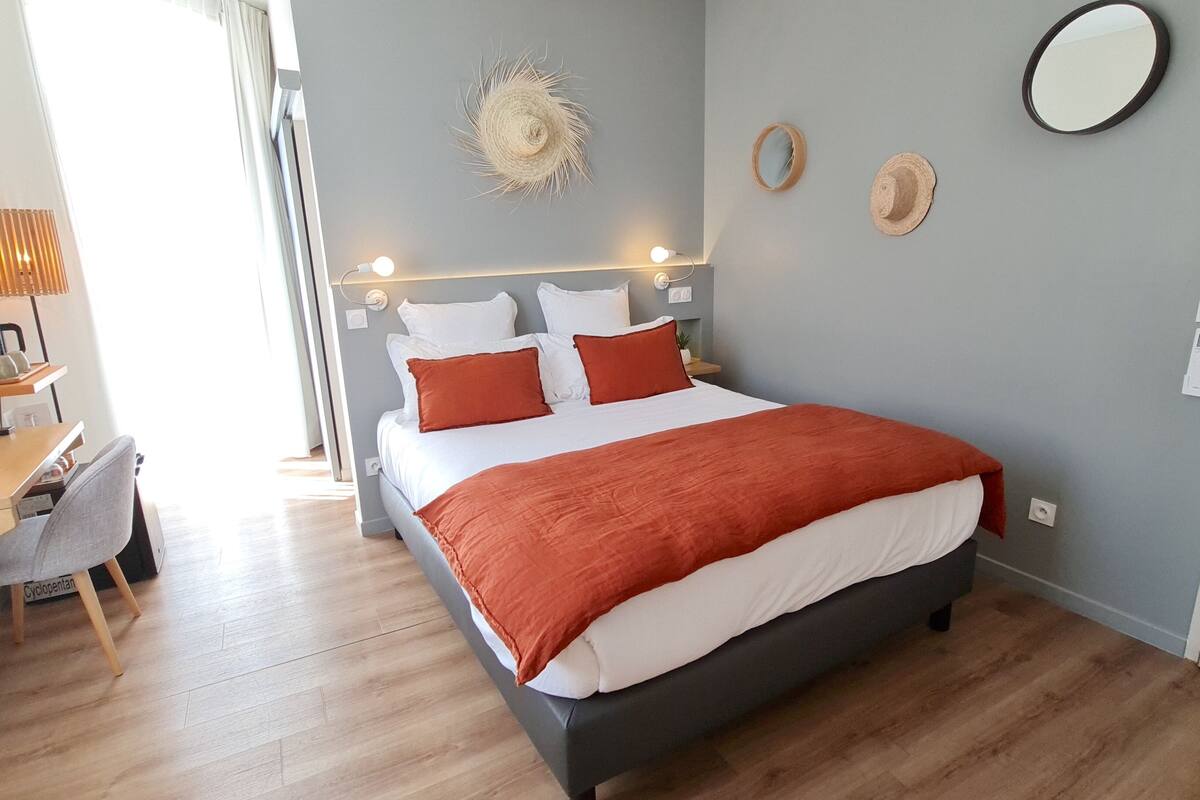 Une chambre d’hôtel moderne, équipée d’un lit, d’un bureau et d’une chaise.