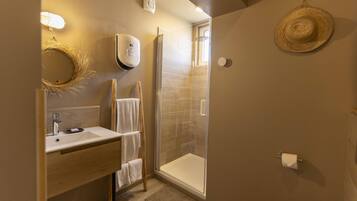 A modern bathroom with a glass-enclosed shower, a wooden vanity, and a towel rack.