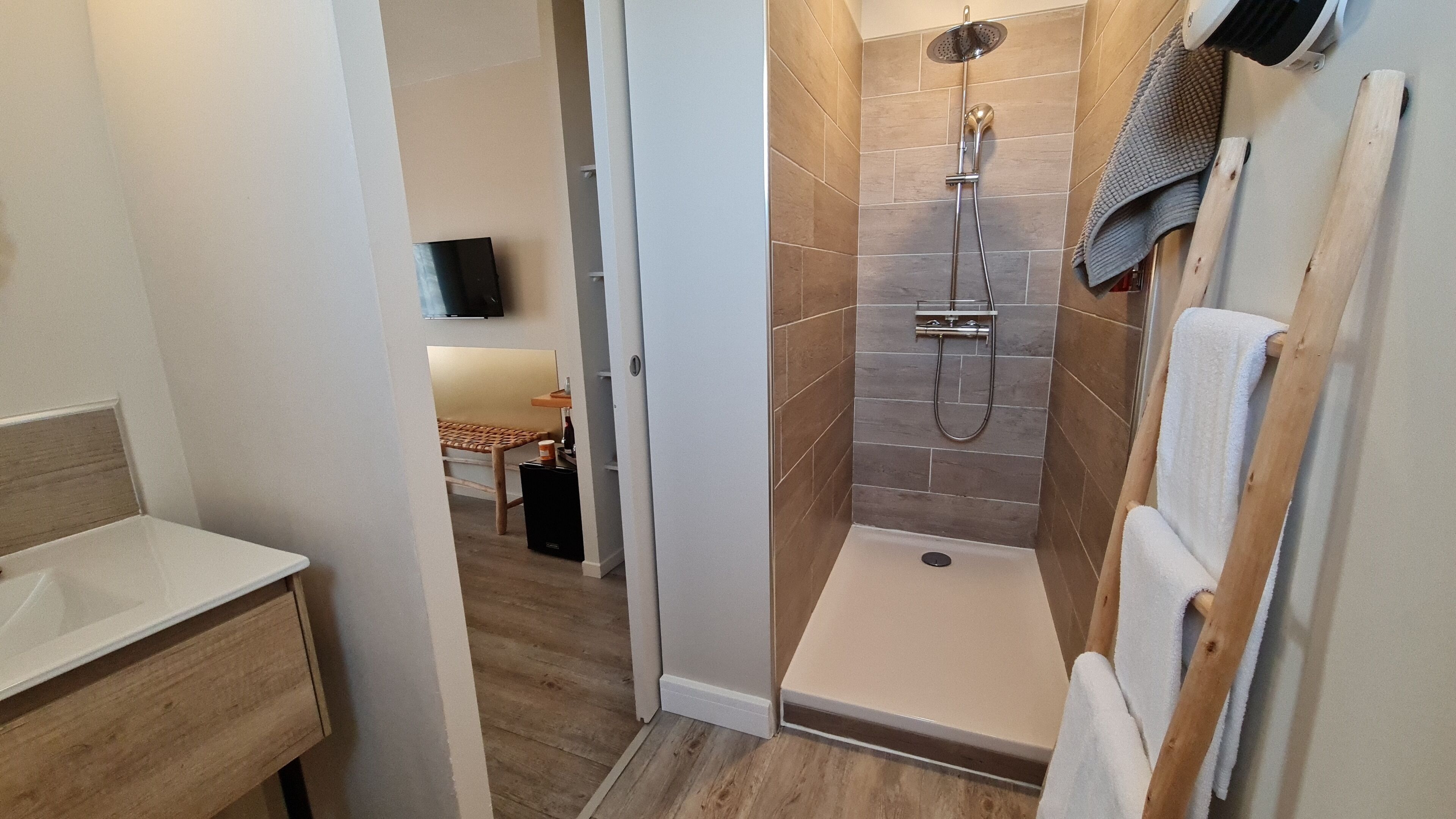 Een moderne badkamer met een douche, wastafel en toilet.