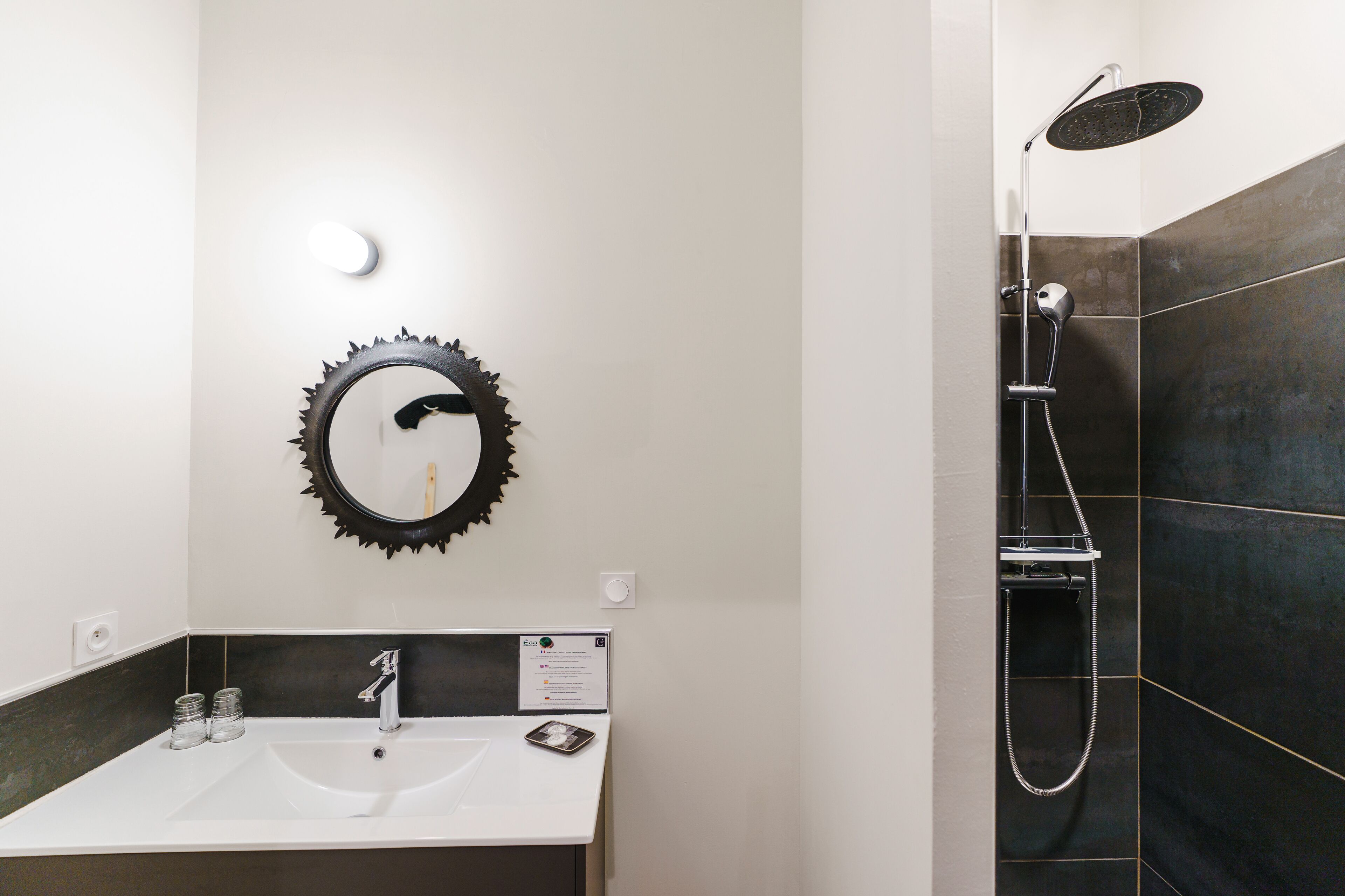 Un baño con lavamanos, espejo y ducha.