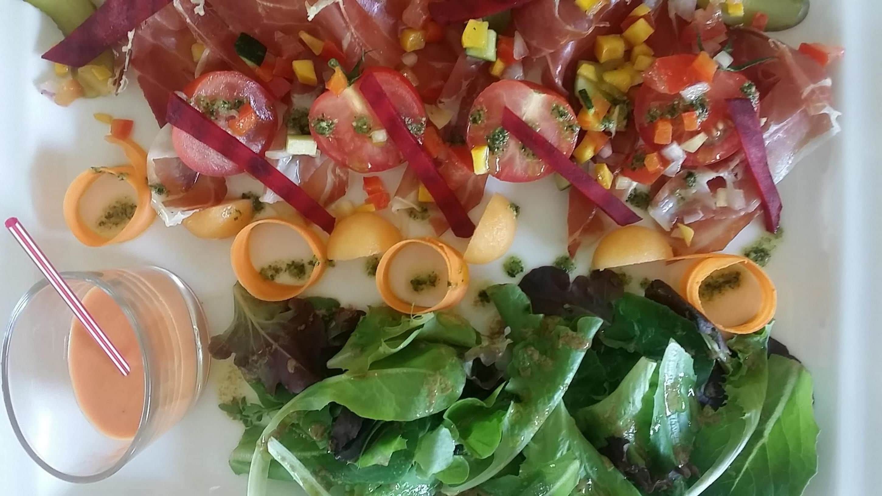 A plate of food with various vegetables and a drink.