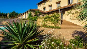 Stunning Mediterranean-style building with a grand staircase, beautifully manicured garden, and a serene swimming pool.