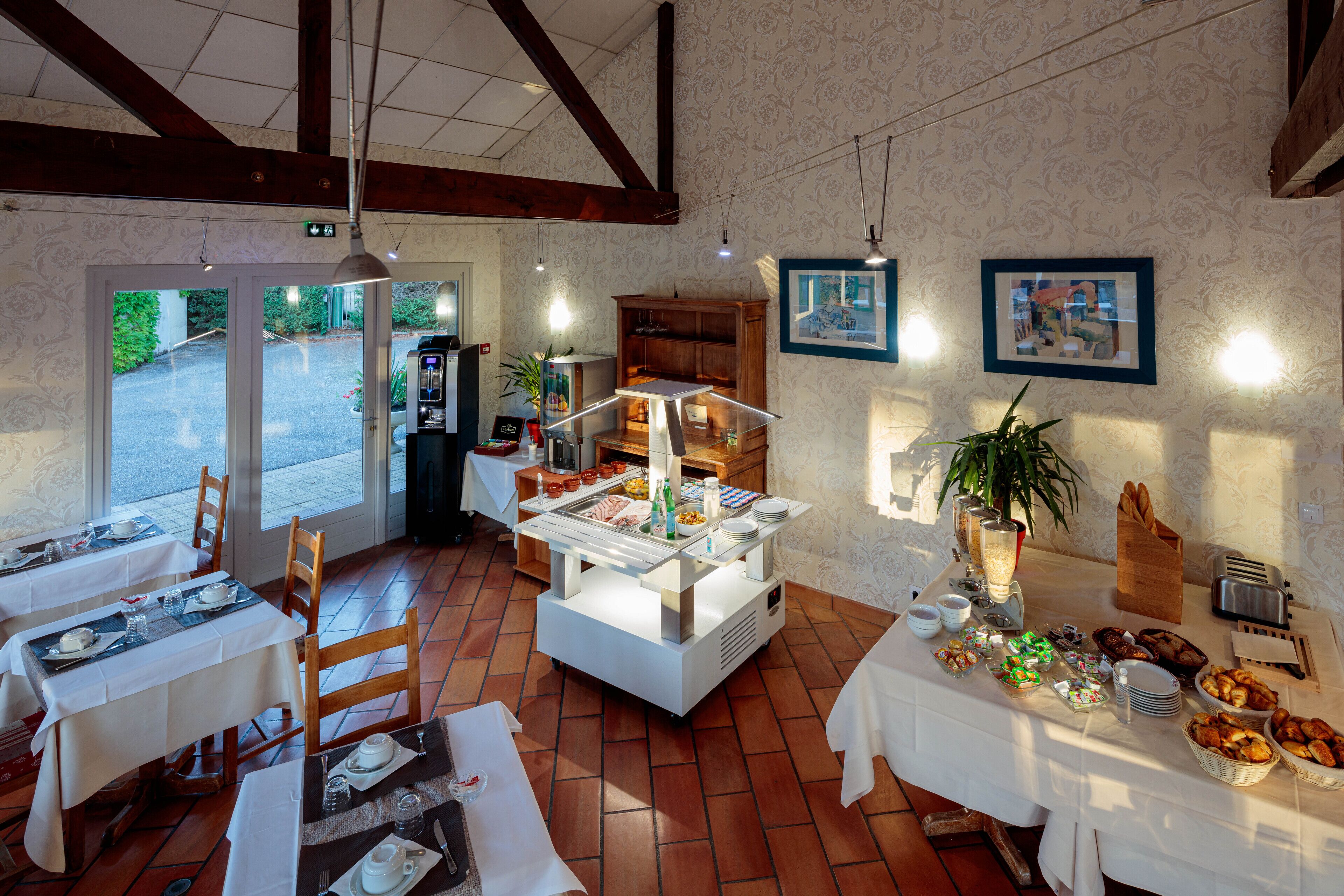 Un montaje de desayuno buffet con varias mesas, una estación de café y una variedad de alimentos.