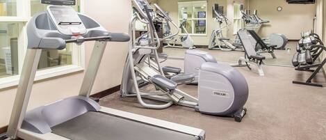 A gym with treadmills, elliptical machines, and weight equipment.