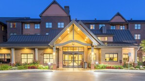 A multi-story hotel with a prominent entrance, large windows, and a brick facade.