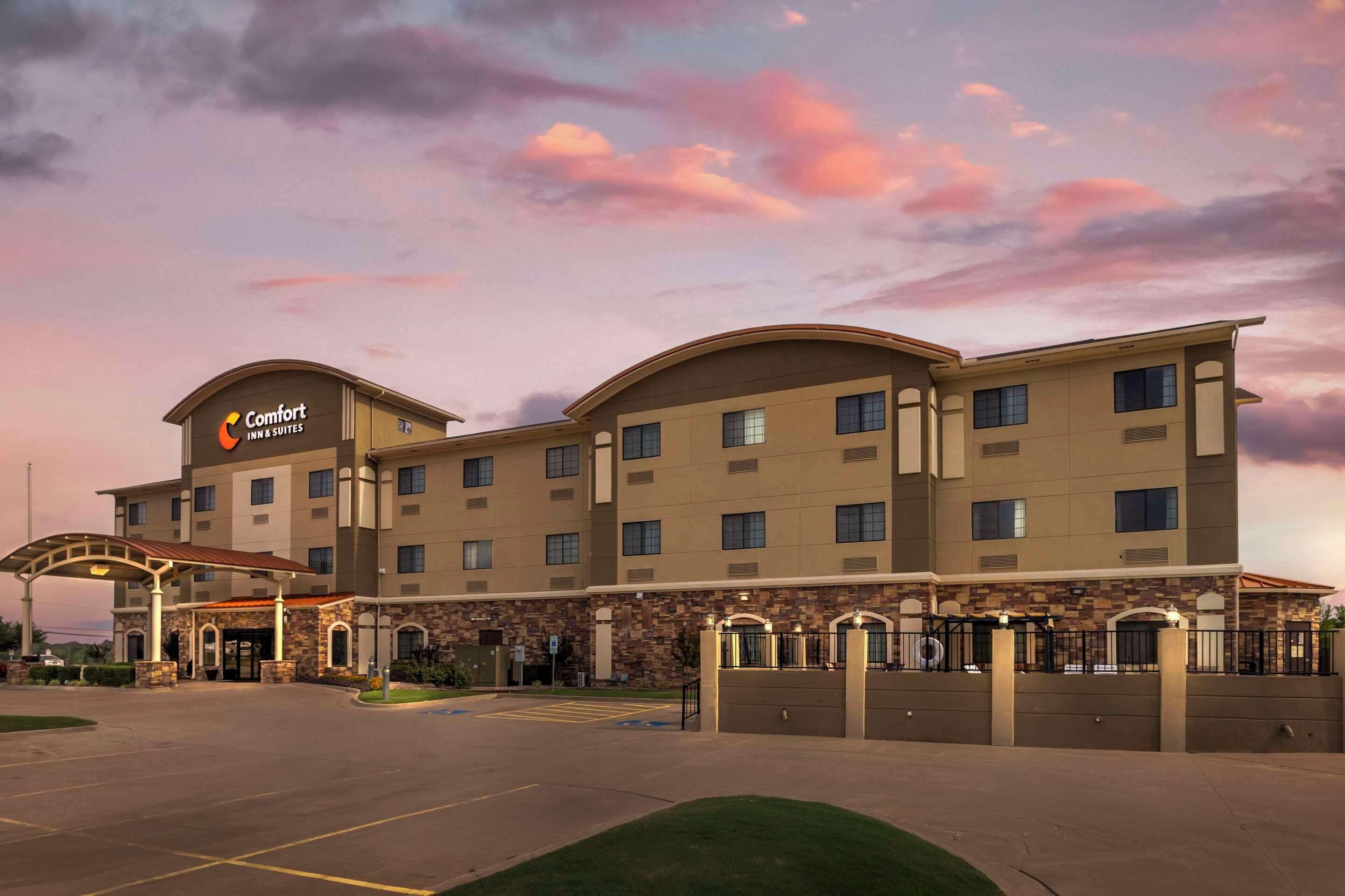 A Comfort Inn Suites hotel with a stone facade, multiple balconies, and a covered entrance.