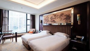 A hotel room with two beds, a desk, a chair, and a large window providing a view of buildings. - Yuntianlou Milan International Hotel (Wenzhou)