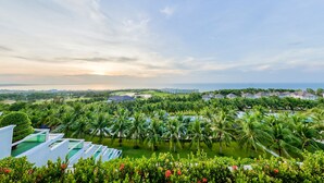 A resort with multiple swimming pools, lush greenery, and a view of the ocean. - Sea Links Beach Hotel (Phu Thuy)