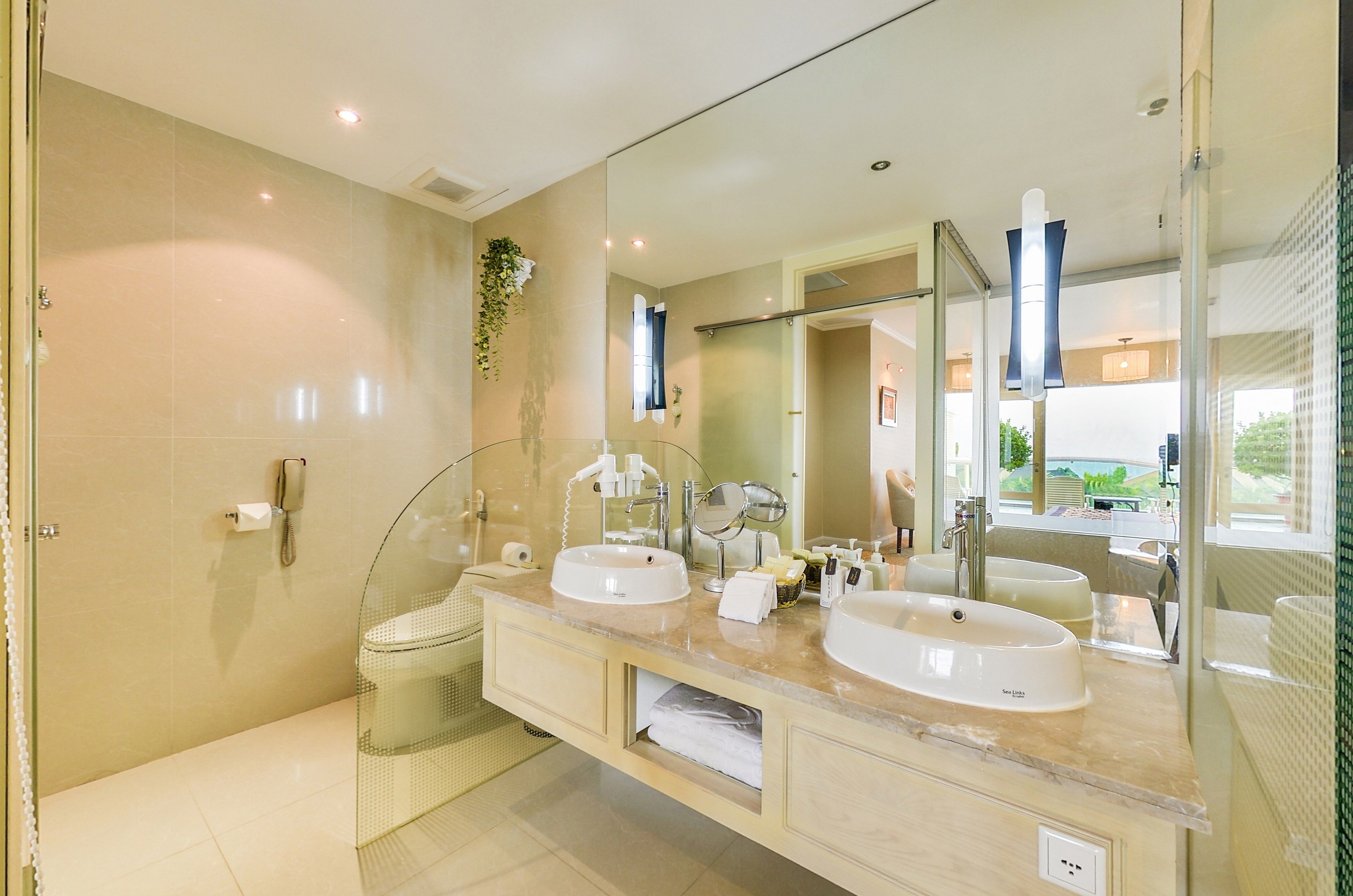 A modern bathroom with two sinks, a large mirror, and a glass shower enclosure.