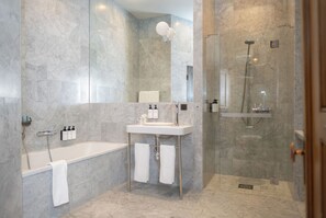 A modern bathroom with a bathtub, a sink, and a glass-enclosed shower. - Nobis Hotel Stockholm, a Member of Design Hotels (Stockholm)