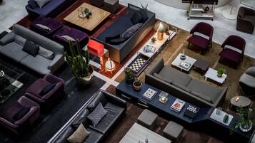 Ein modernes Wohnzimmer mit mehreren Sitzgruppen, einem Couchtisch und einem Bücherregal.