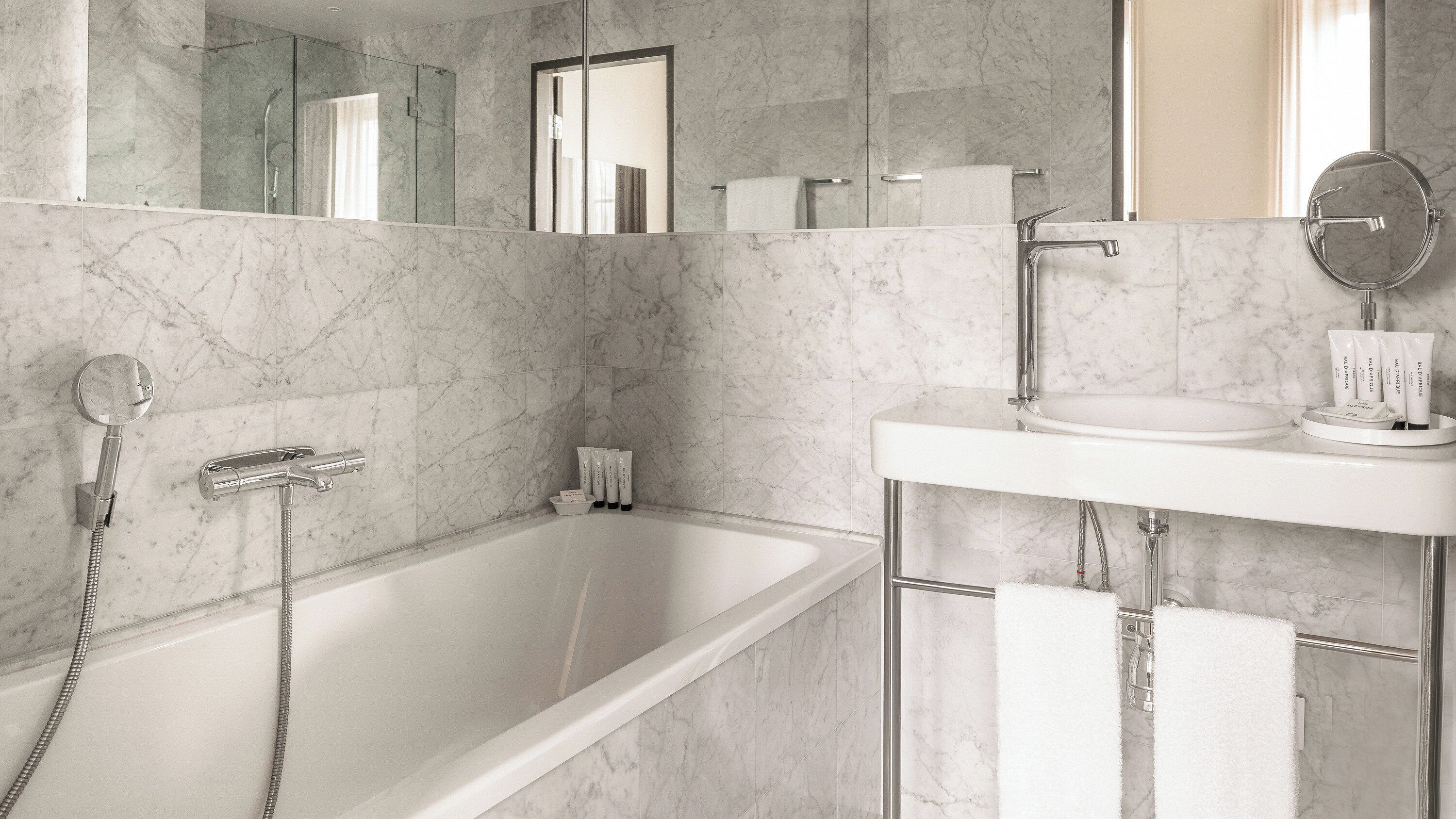 A modern bathroom with a bathtub, a sink, and a mirror.