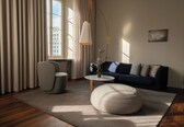 A modern living room with a sofa, ottoman, and a coffee table.