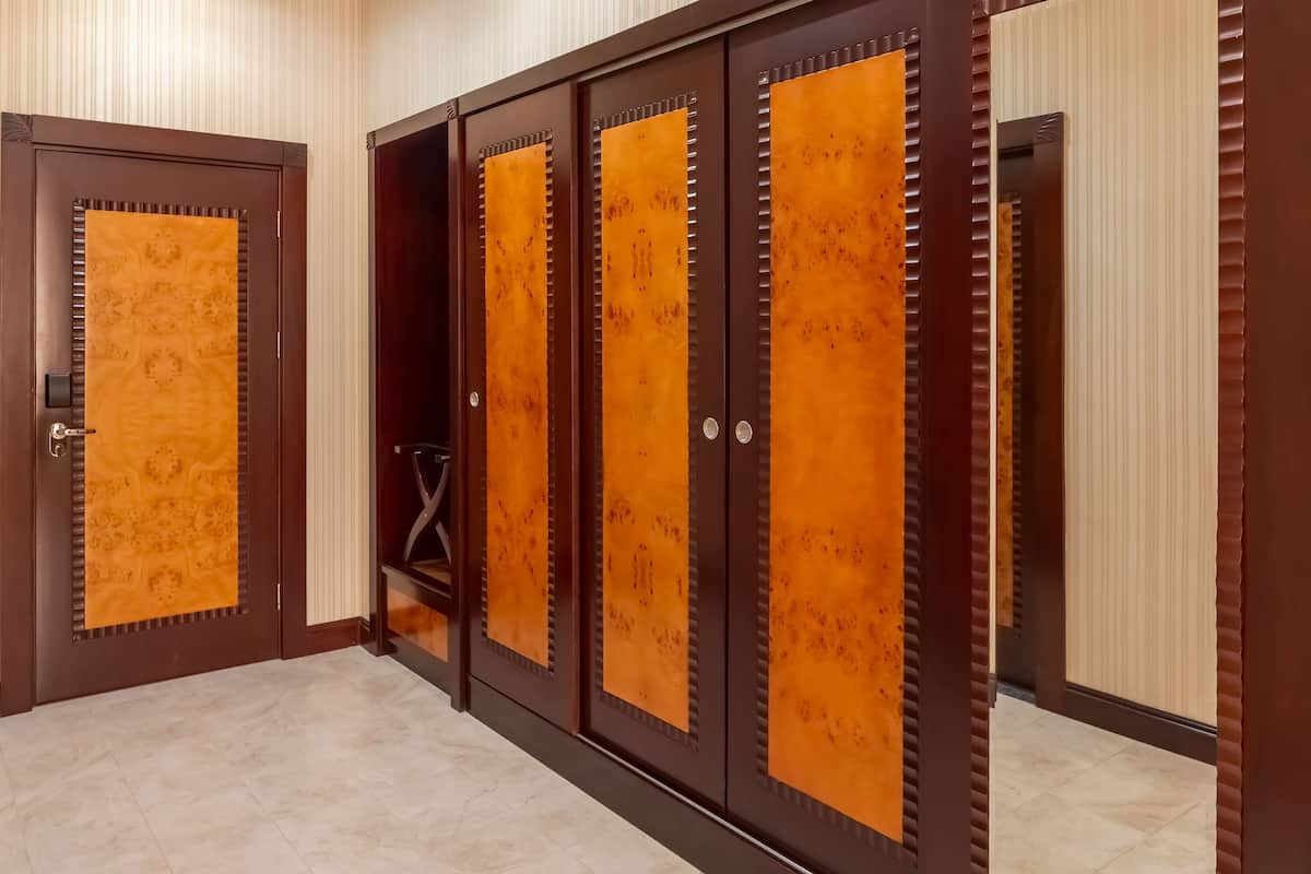 Un pasillo con una serie de puertas, cada una con un diseño único y un pomo metálico.