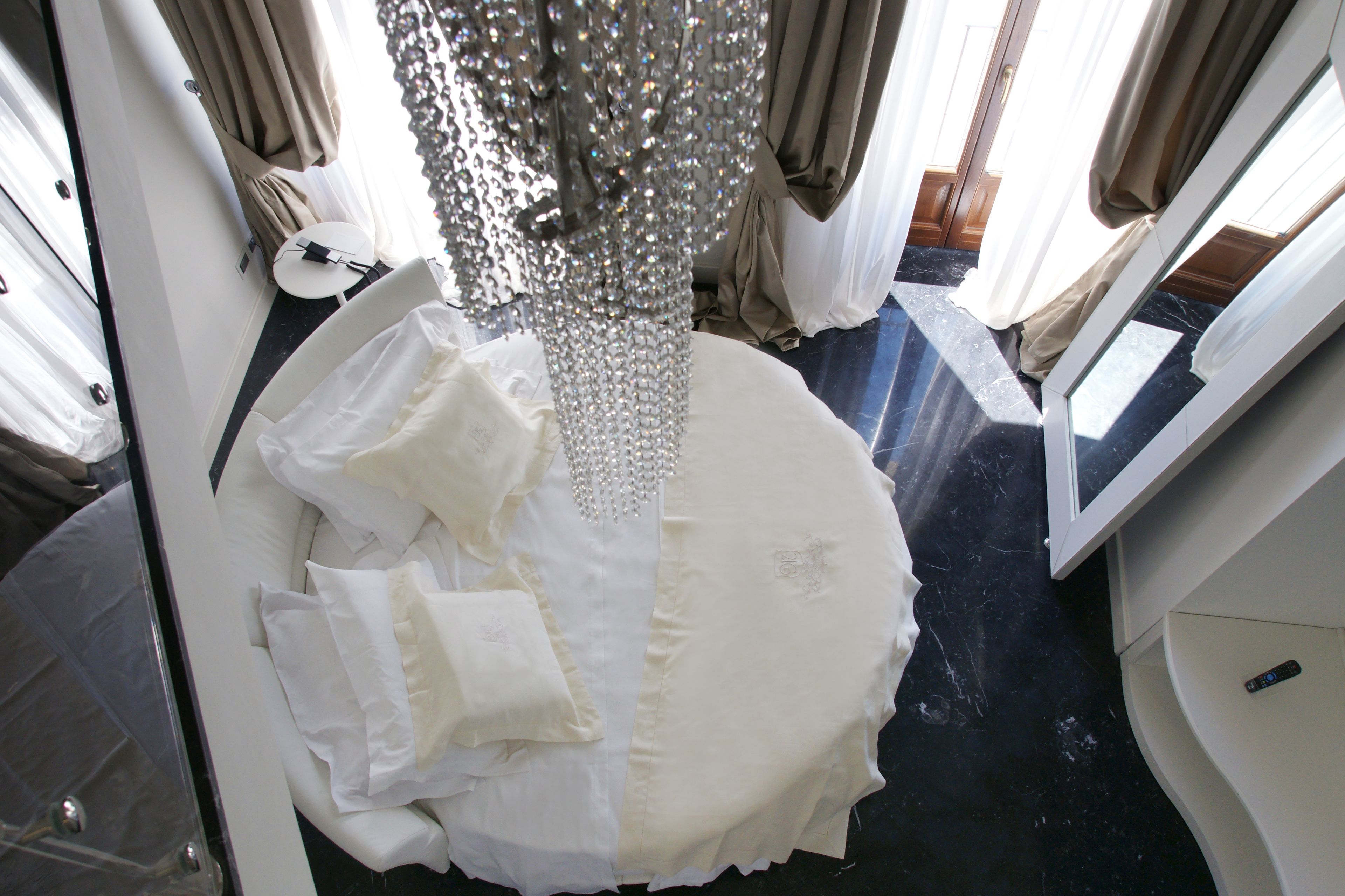 A room with a bed, a chandelier, and a satellite dish.