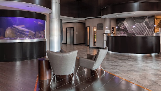 A modern lobby with a reception desk, seating area, and an aquarium. - Springhill Suites by Marriott Waco Woodway (Waco)