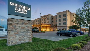 A hotel entrance with a sign reading "SPRINGHILL SUITES BY MARRIOTT," a parking lot, and a building with multiple windows and a stone facade. - Springhill Suites by Marriott Waco Woodway (Waco)