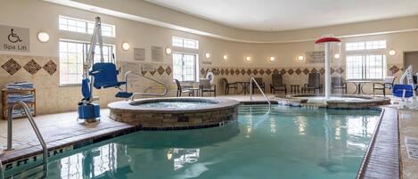 Un espace piscine équipé d’un ascenseur pour personnes à mobilité réduite, d’un jacuzzi et d’un coin salon.