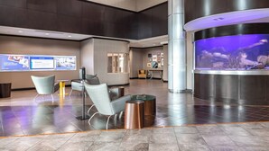 A modern lobby with a reception desk, seating area, and a large aquarium. - Springhill Suites by Marriott Waco Woodway (Waco)