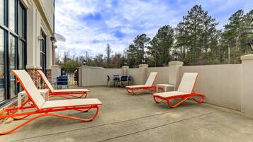 A patio area with outdoor seating and a view of trees.