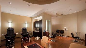 A modern hair salon with multiple seating areas, a reception desk, and a mirror.