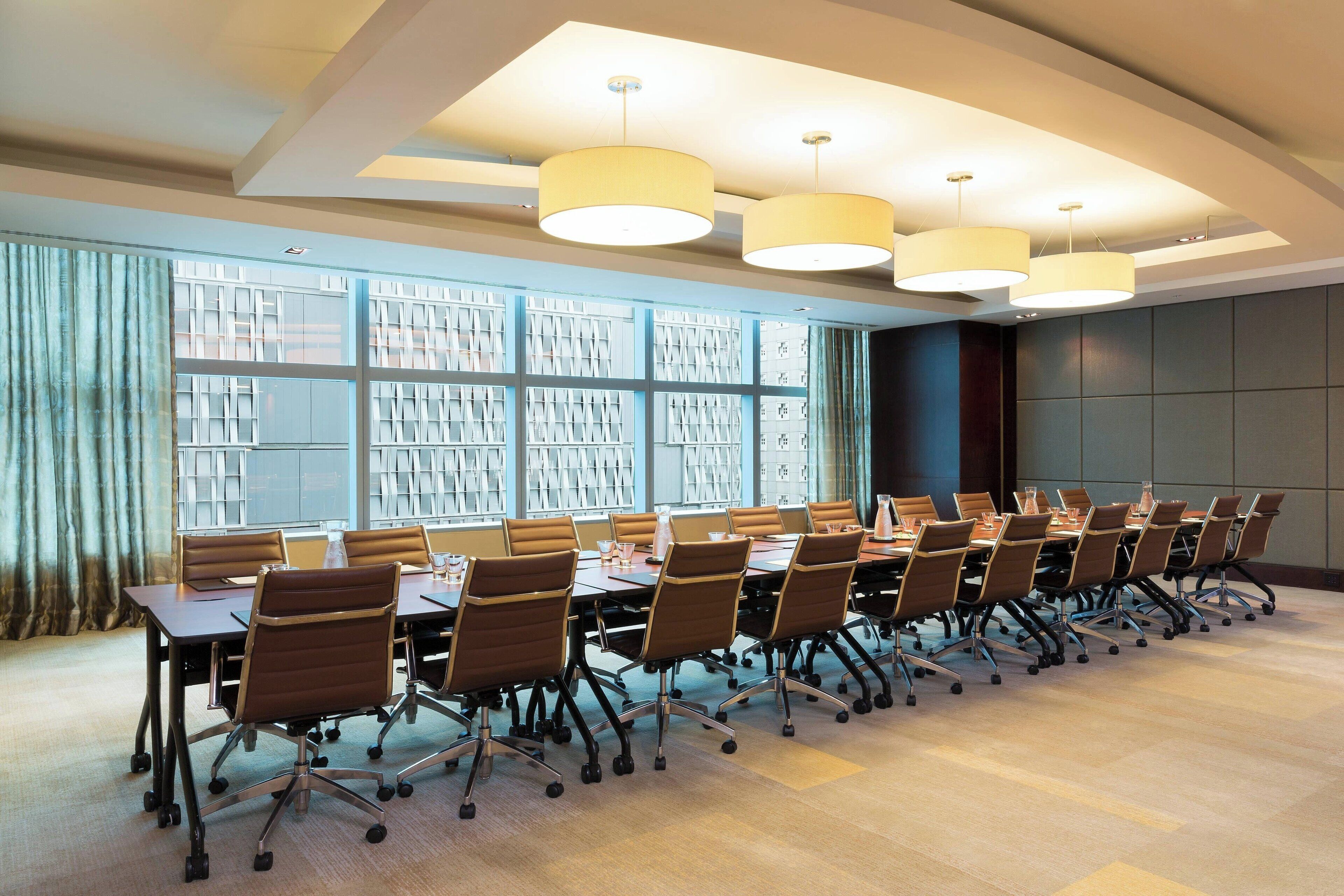 A conference room with a long table, chairs, and overhead lighting.