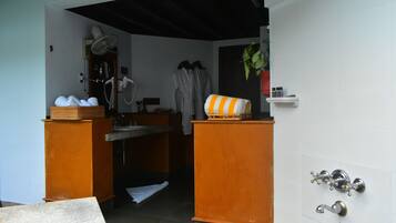 A room with a shower, a sink, a mirror, and a towel rack.