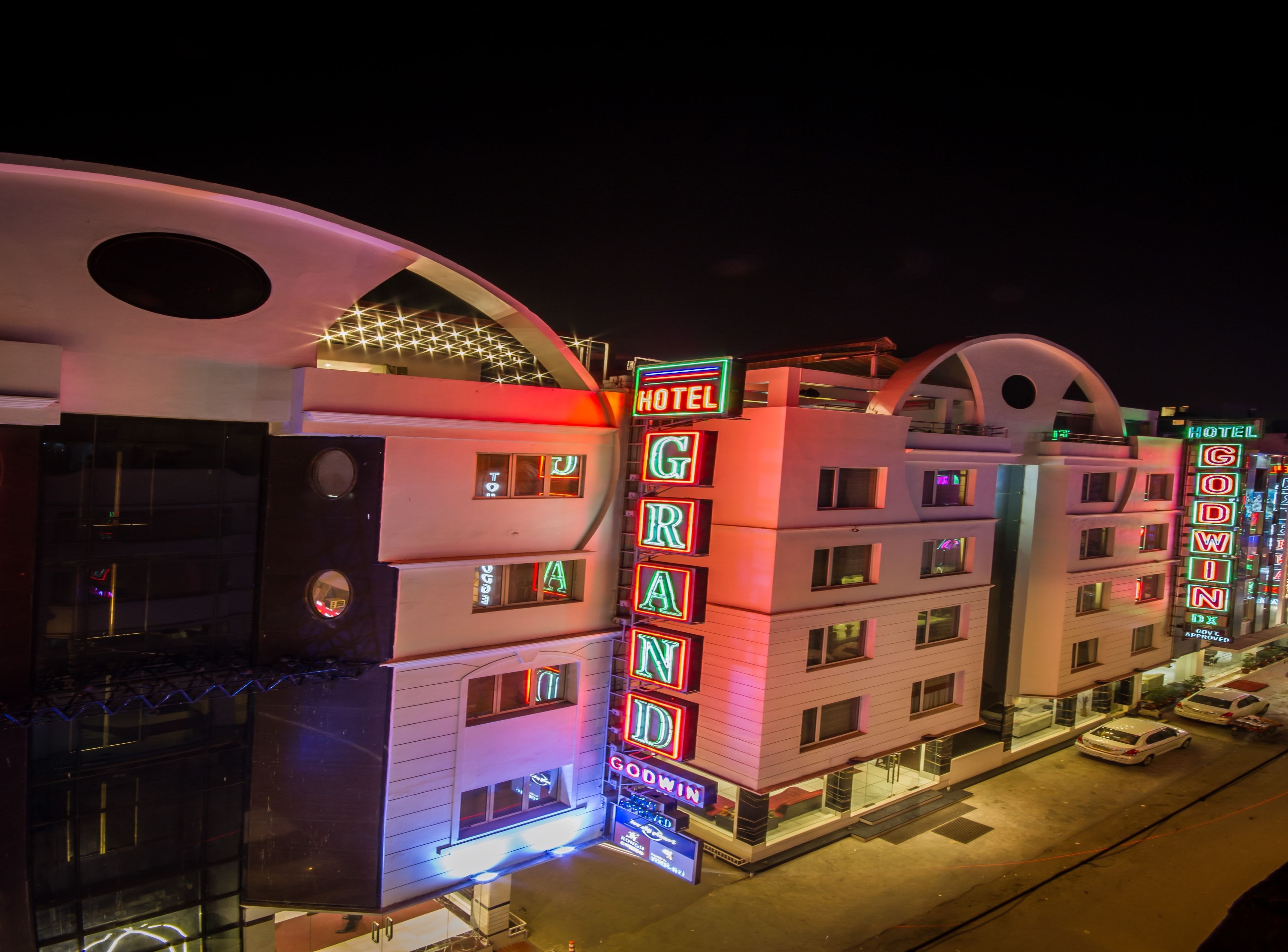 A hotel with multiple stories, neon signage, and a distinctive arched entrance.
