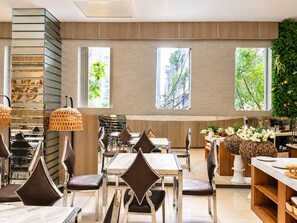 Ein modernes Restaurantambiente mit einem zentralen Essbereich, mehreren Tischen und Stühlen.