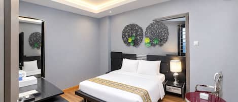 A modern hotel room with a bed, bedside table, lamp, and a mirror.