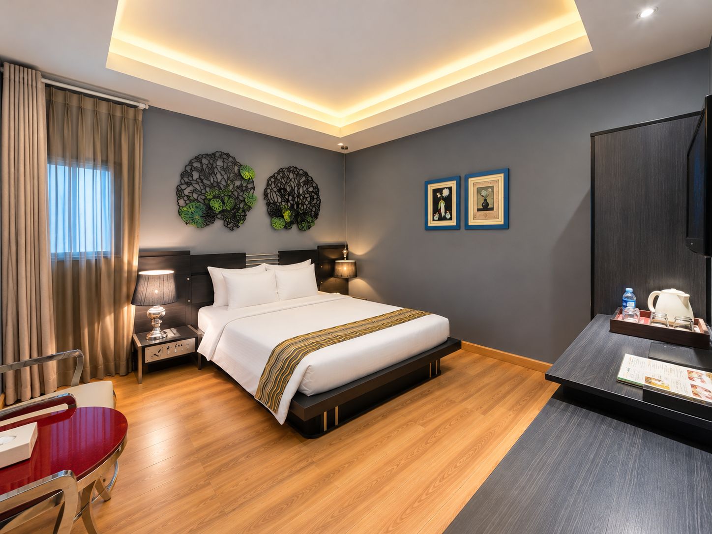 A hotel room with a bed, bedside tables, a desk, and a chair.