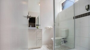 A bathroom with a glass-enclosed shower, a white sink, and a mirror above it. - Comfort Inn Western (Warrnambool)