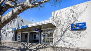 A Comfort Inn Western hotel entrance with a clear sky and shadows cast by trees. - Comfort Inn Western (Warrnambool)
