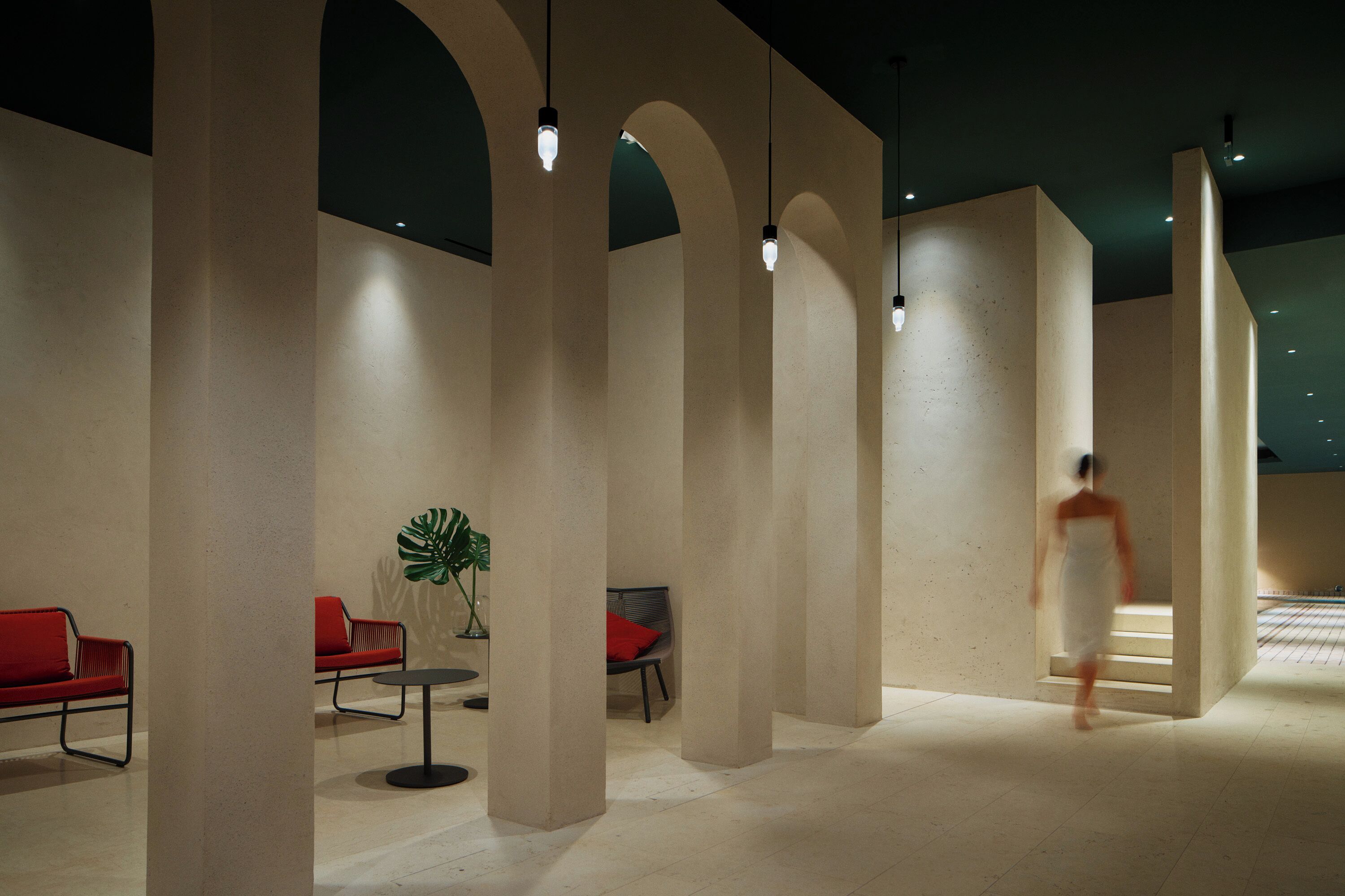 A modern interior with high ceilings, arched columns, and minimalist furniture.