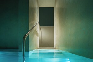 A narrow, enclosed pool area with a metal handrail and a square opening at the end. - Hotel Regina Adelaide (Garda)