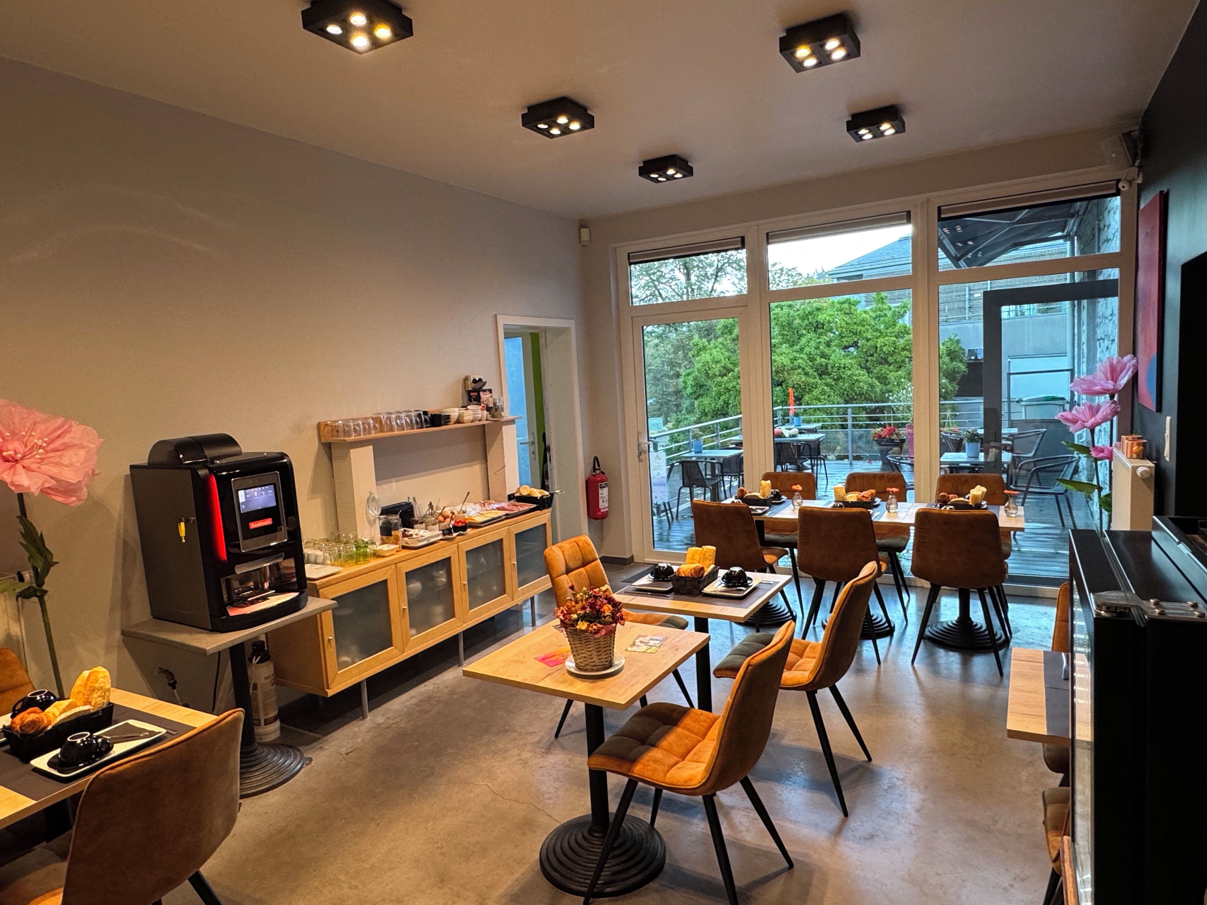 Un espace repas moderne avec des tables, des chaises et une machine à café.
