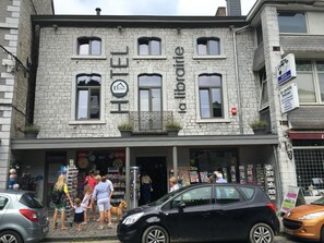 Un edificio con fachada de piedra, varias ventanas y un letrero que indica que es un hotel.