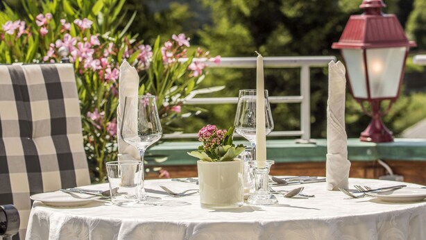 Mesa lista para comer con vista a una montaña e iglesia al fondo.