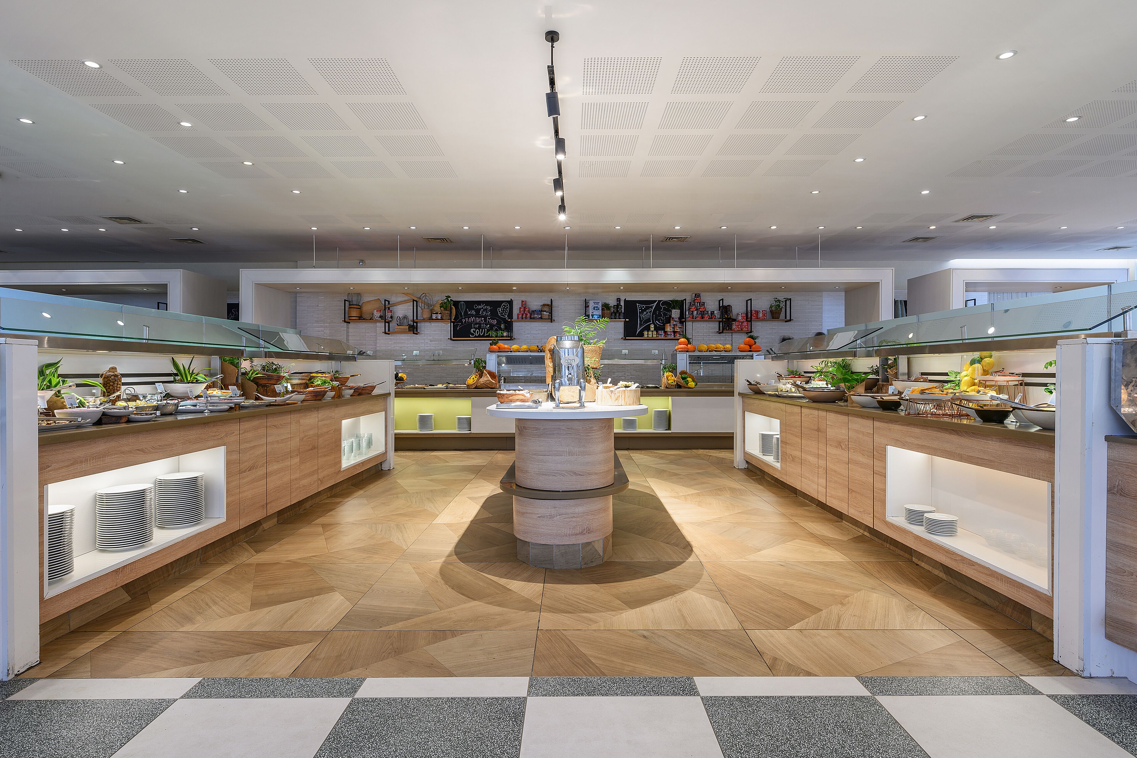 A modern kitchen with a central island, wooden cabinets, and a herringbone floor pattern.