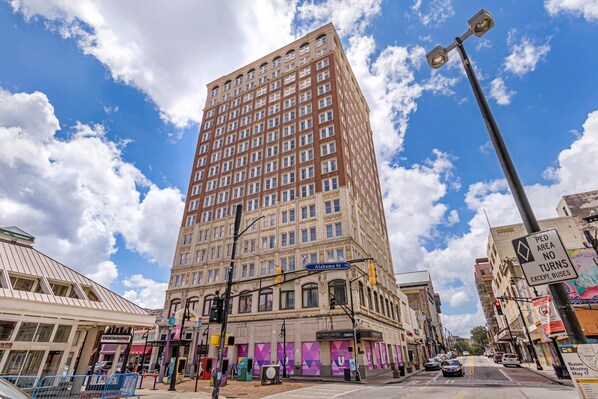 A tall building with multiple windows and a street sign indicating 'Alabama St.'
