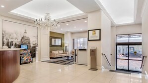 A hotel lobby with a reception desk, a chandelier, a sofa, and a coffee table. - The Connally Hotel Downtown Atlanta, an Ascend Collection Hotel (Atlanta)