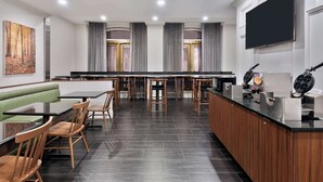 A modern restaurant with a long counter, wooden chairs, and a green booth. - The Connally Hotel Downtown Atlanta, an Ascend Collection Hotel (Atlanta)