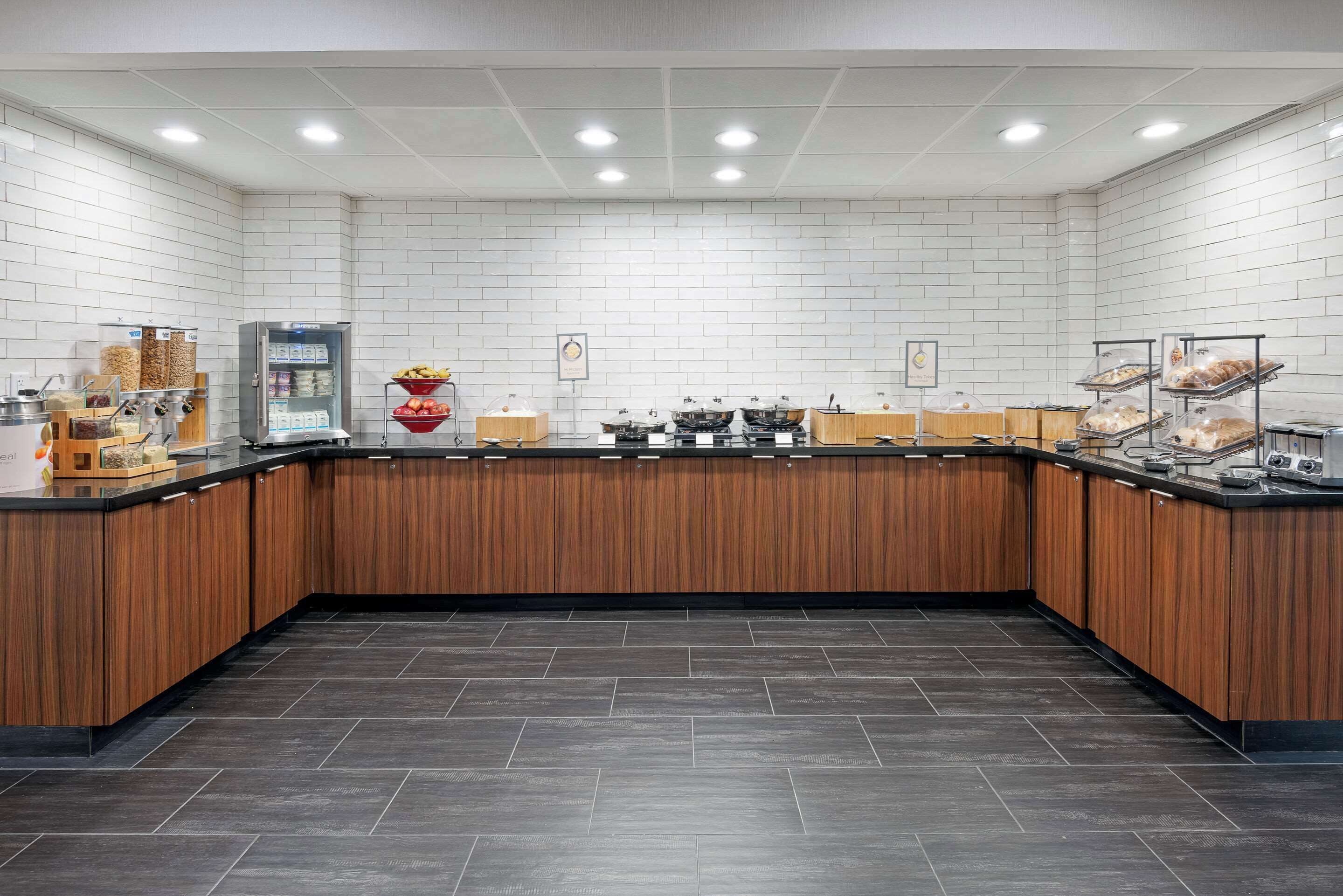 Een moderne keuken met een houten aanrecht, een koelkast en diverse etenswaren.