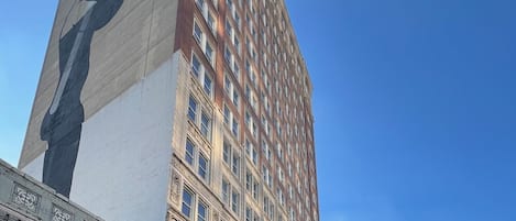 A tall building with a facade featuring a large, dark-colored mural.