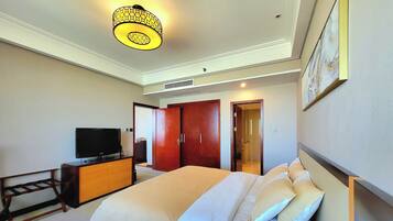 Une chambre d’hôtel comprenant un lit, une télévision, une commode et une porte donnant sur une salle de bain.